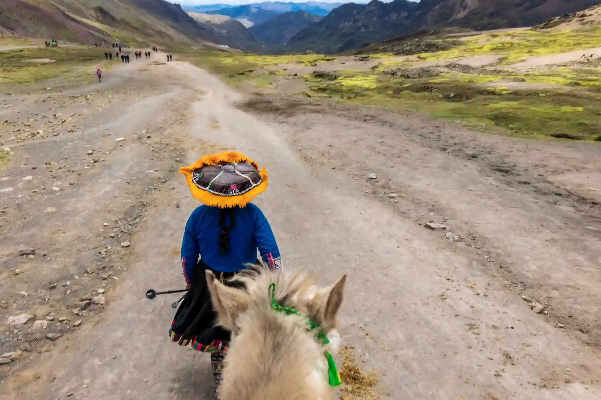 peruvian-woman-traditional-hat-leads-horse-vinikunka-peru-rainbow-mountains-cusco